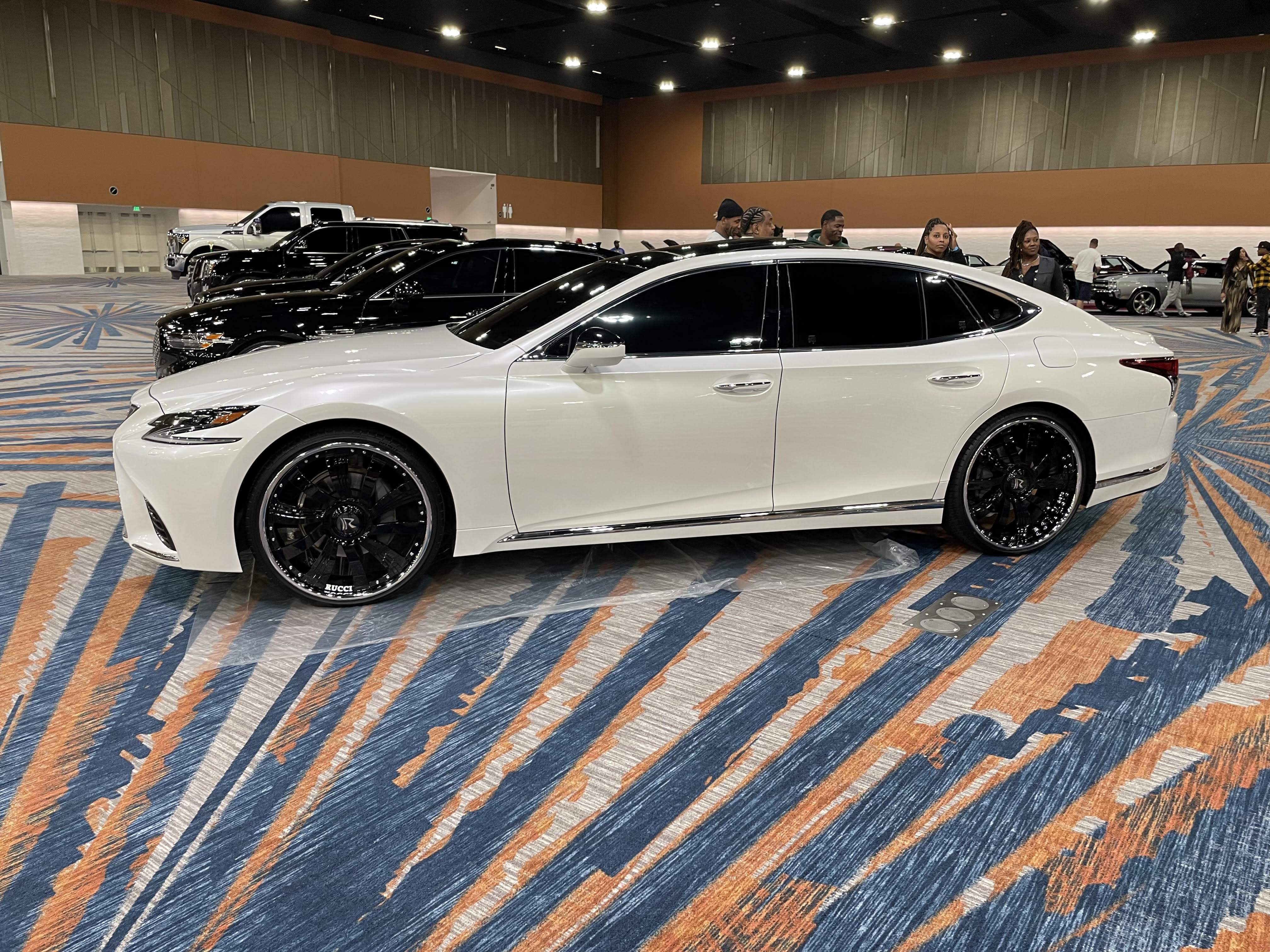 White luxury sedan showcased on the expo floor