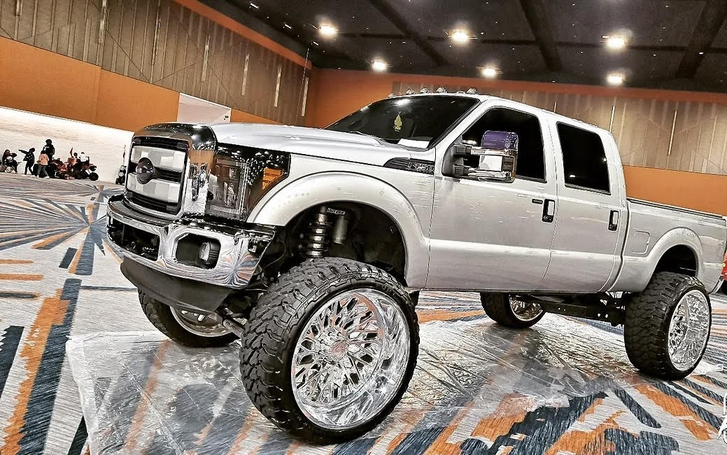 Silver lifted Ford truck with chrome wheels at the expo